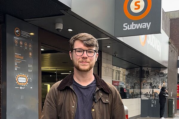Daniel O'Malley standing outside the Hillhead subway station in Glasgow.