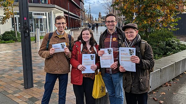 A group of 4 Lib Dem activists holding up Glasgow resident surveys