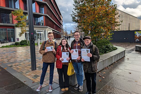 A group of 4 Lib Dem activists holding up Glasgow resident surveys