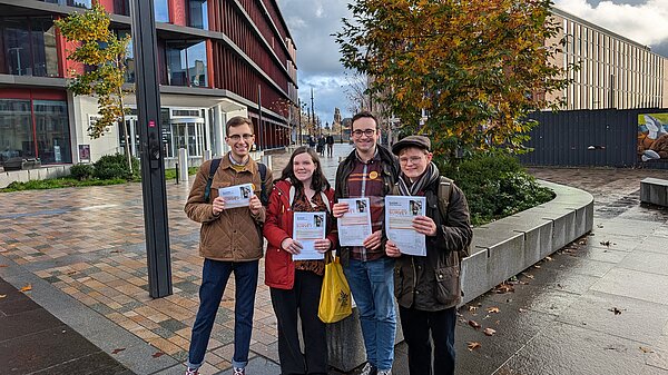A group of 4 Lib Dem activists holding up Glasgow resident surveys